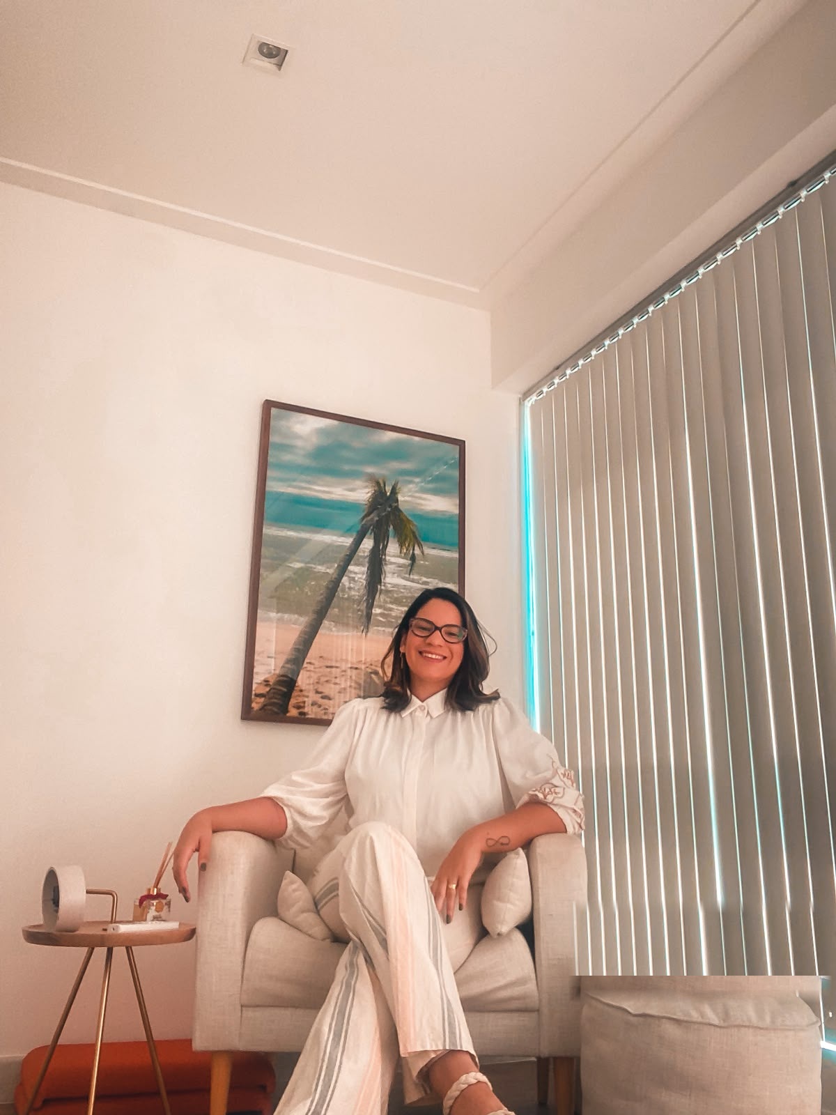 Milena Sallenave, psicóloga, sorrindo em ambiente acolhedor